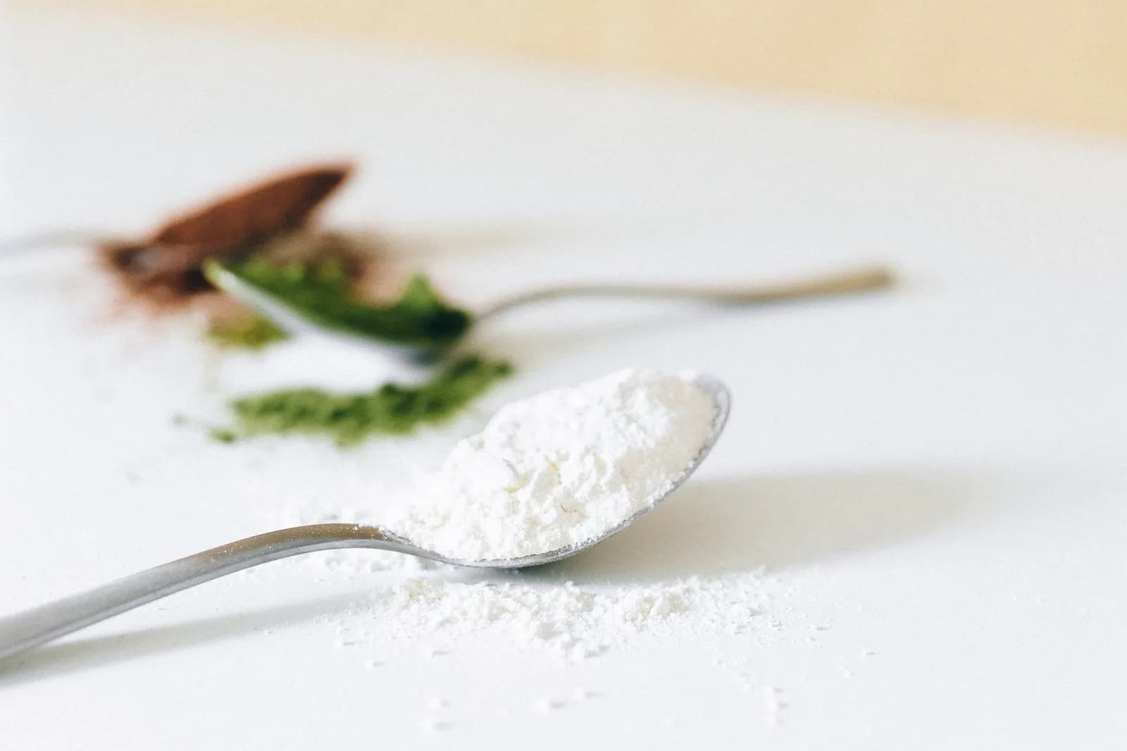 A heaped spoon of fine white powder on a white surface